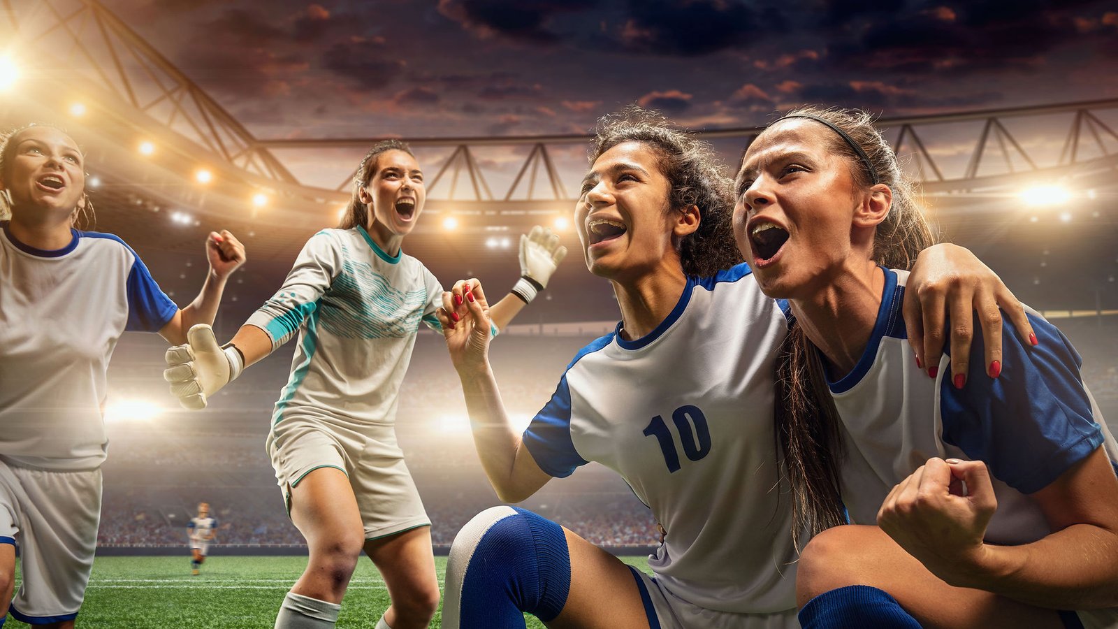 young women soccer players celebrating score